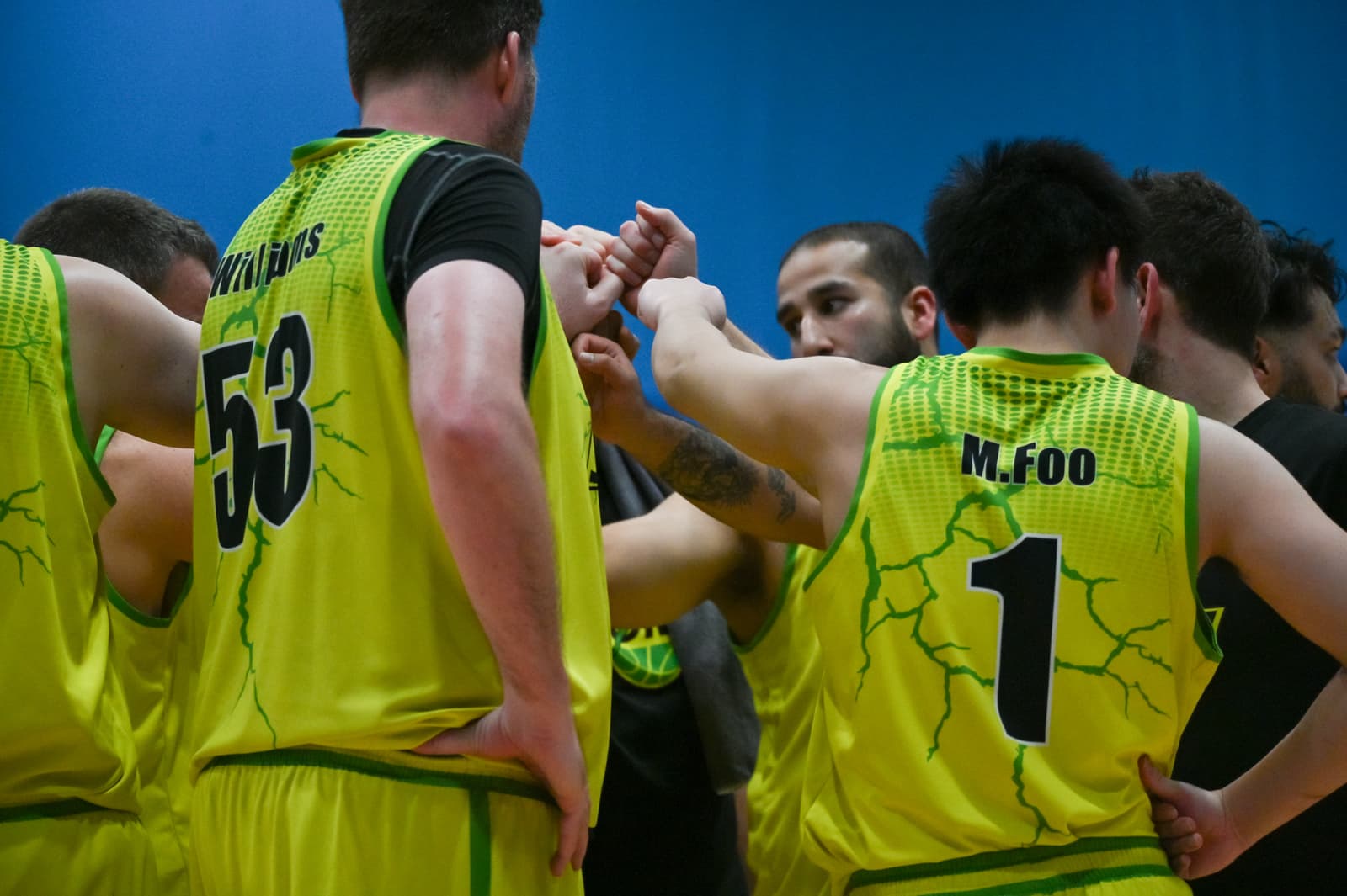 Alton Storm players joining hands in a team huddle